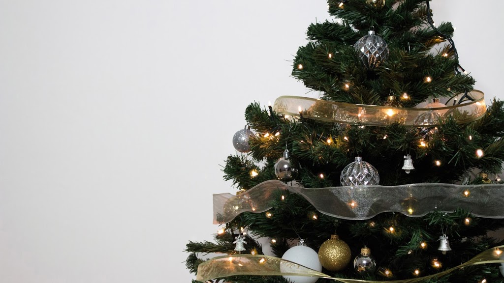 Christmas tree decorated with silver, gold and white baubles, wrapped with gold a silver ribbons.