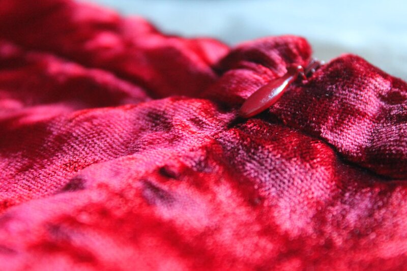 Close-up of a zipper on a Krizia Poi skirt made from dark red velvet fabric